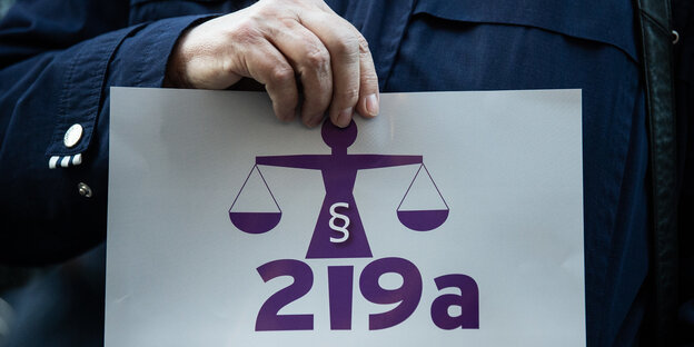 Jemand hält ein Schild hoch, auf dem 219a steht Jemand hält ein Schild hoch, auf dem 219a steht