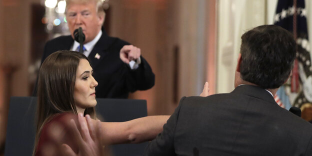 Trump zeigt mit dem Finger auf einen Mann, der nur von hinten zu sehen ist Trump zeigt mit dem Finger auf einen Mann, der nur von hinten zu sehen ist