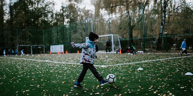 Ein Kind schießt einen Fußball Ein Kind schießt einen Fußball