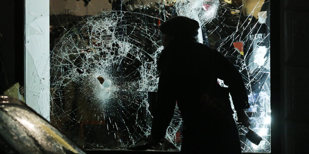 Eine Passantin vor einem gesprungenen Schaufenster Eine Passantin vor einem gesprungenen Schaufenster