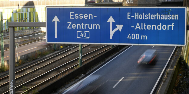 Eine Autobahn, über der ein blaues Autobahnschild hängt Eine Autobahn, über der ein blaues Autobahnschild hängt