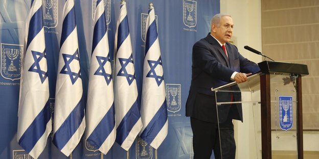 Benjamin Netanjahu, Israels Ministerpräsident, steht neben Israel-Fahnen an einem Pult Benjamin Netanjahu, Israels Ministerpräsident, steht neben Israel-Fahnen an einem Pult
