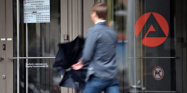 Ein Mann geht am Eingang der Agentur für Arbeit vorbei Ein Mann geht am Eingang der Agentur für Arbeit vorbei