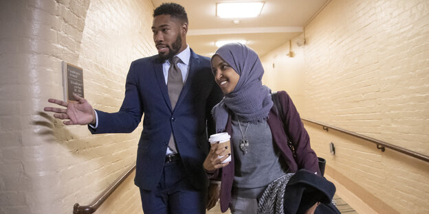 Ilhan Omar steht mit Kopftuch neben einem Mann im Anzug