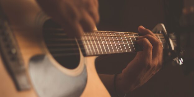 Jemand spielt auf einer Gitarre Jemand spielt auf einer Gitarre