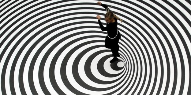 ein Mädchen springt auf einer auf den Boden gezeichneten Spirale ein Mädchen springt auf einer auf den Boden gezeichneten Spirale