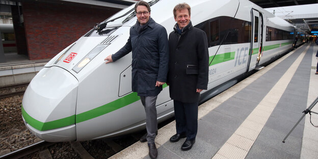 Vor einem Zug mit grünem Streifen stehen der Bundesverkehrsminister Scheuer (CSU) und der Bahnchef Lutz Vor einem Zug mit grünem Streifen stehen der Bundesverkehrsminister Scheuer (CSU) und der Bahnchef Lutz