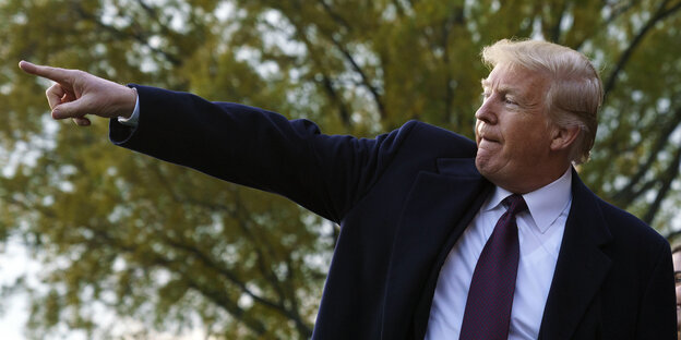 Donald Trump deutet mit dem Zeigefinger auf etwas Donald Trump deutet mit dem Zeigefinger auf etwas