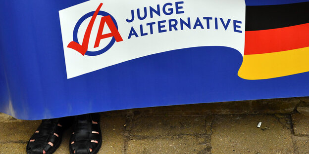 Sandalen hinter einer Banderole der AfD-Jugendorganisation Sandalen hinter einer Banderole der AfD-Jugendorganisation