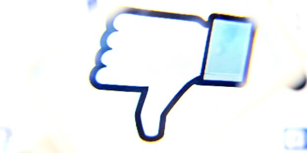 Ein Computer-Bildschrim zeigt einen Facebook-Daumen, der durch eine Lupe betrachtet umgekehrt ist Ein Computer-Bildschrim zeigt einen Facebook-Daumen, der durch eine Lupe betrachtet umgekehrt ist