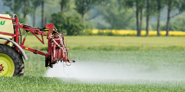 Ein Landwirt fährt mit einer Dünger- und Pestizidspritze über ein Feld Ein Landwirt fährt mit einer Dünger- und Pestizidspritze über ein Feld