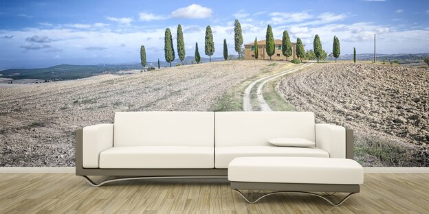 Ein Sofa vor einer toskanischen Landschaftstapete Ein Sofa vor einer toskanischen Landschaftstapete