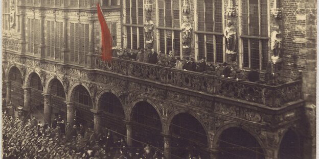 Eine rote Flagge prangt am Bremer Rathaus. Es ist eine historische Fotografie von der Novemberrevolution 1918 Eine rote Flagge prangt am Bremer Rathaus. Es ist eine historische Fotografie von der Novemberrevolution 1918