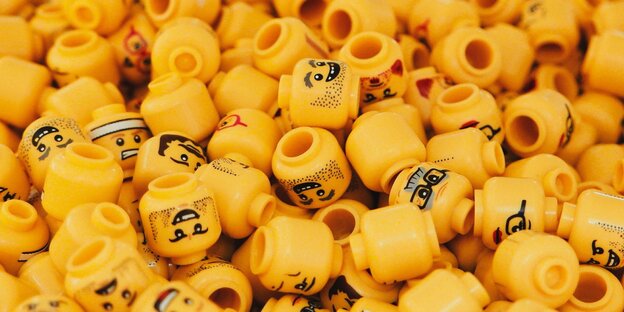 Ein Haufen gelber Köpfe von Legomännchen Ein Haufen gelber Köpfe von Legomännchen