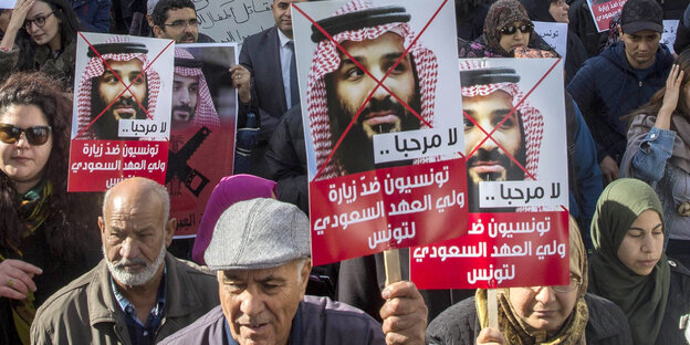 Demonstranten halten Plakate mit dem durchgestrichenen Bild des saudischen Kronprinzen Demonstranten halten Plakate mit dem durchgestrichenen Bild des saudischen Kronprinzen