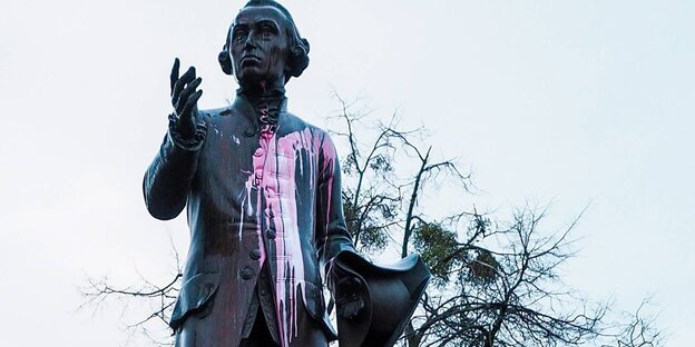 Eine mit einer pinken Farbbombe beworfene Statue von Immanuel Kant Eine mit einer pinken Farbbombe beworfene Statue von Immanuel Kant