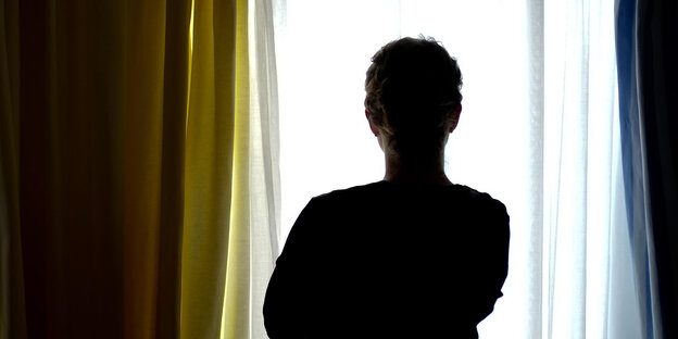 Eine Frau blilckt aus einem Fenster. Eine Frau blilckt aus einem Fenster.