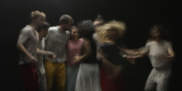 Eine Gruppe Tänzer*innen auf einer Theaterbühne. Eine Gruppe Tänzer*innen auf einer Theaterbühne.