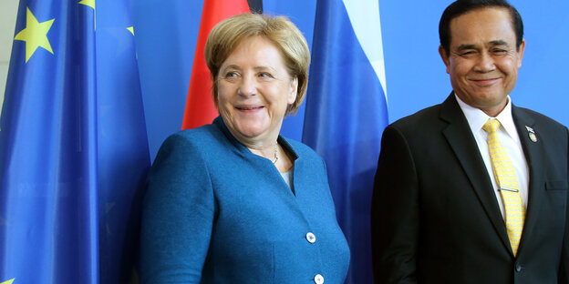 Angela Merkel steht neben Prayut Chan-o-cha. Beide lächeln Angela Merkel steht neben Prayut Chan-o-cha. Beide lächeln