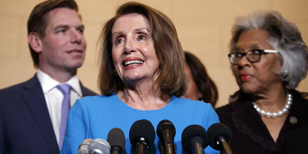 Nancy Pelosi, eine Frau mit braunen schulterlangen Haaren spricht in mehrere Mikrofone Nancy Pelosi, eine Frau mit braunen schulterlangen Haaren spricht in mehrere Mikrofone