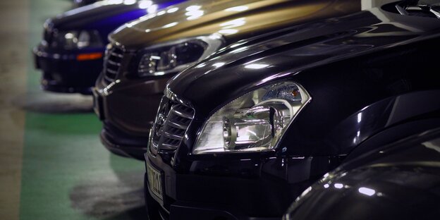 Große Autos ragen aus einem Parkplatz heraus Große Autos ragen aus einem Parkplatz heraus