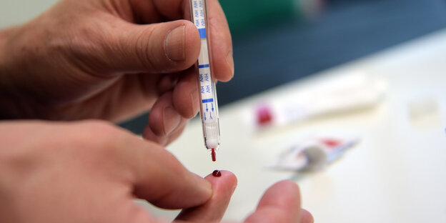 Ein junger Mann führt einen HIV-Heimtest durch Ein junger Mann führt einen HIV-Heimtest durch