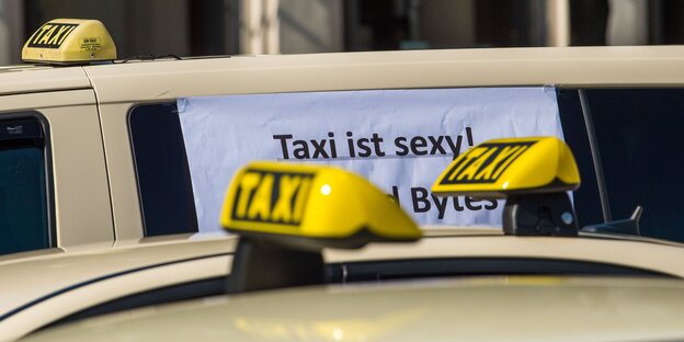 Taxidächer und ein Zettel auf einer Scheibe, auf dem steht "Taxi ist sexy" Taxidächer und ein Zettel auf einer Scheibe, auf dem steht "Taxi ist sexy"