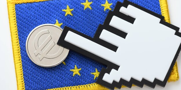 Eine computeranimierte Hand zeigt auf eine Münze, die auf einer EU-Flagge liegt Eine computeranimierte Hand zeigt auf eine Münze, die auf einer EU-Flagge liegt
