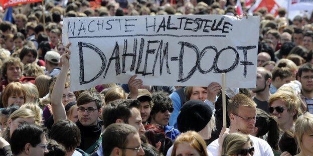 Menschen im Pulk tragen ein Plakat Menschen im Pulk tragen ein Plakat