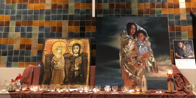 Neben einem klassischen religiösen Heiligenbild lehnt das Bild einer Geflüchteten mit Baby Neben einem klassischen religiösen Heiligenbild lehnt das Bild einer Geflüchteten mit Baby