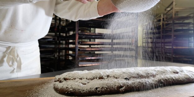 Puderzucker wird über einen Stollen gestreut Puderzucker wird über einen Stollen gestreut