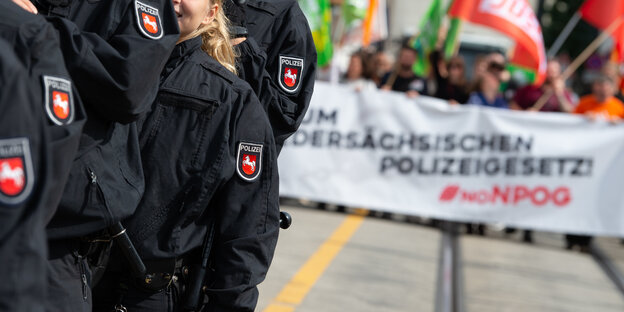 Polizisten und Demonstranten mit Plakat gegen das Polizeigesetz Polizisten und Demonstranten mit Plakat gegen das Polizeigesetz