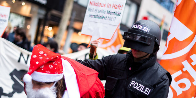 Ein verkleideter Polizist führt einen verkleideten Nikolaus ab