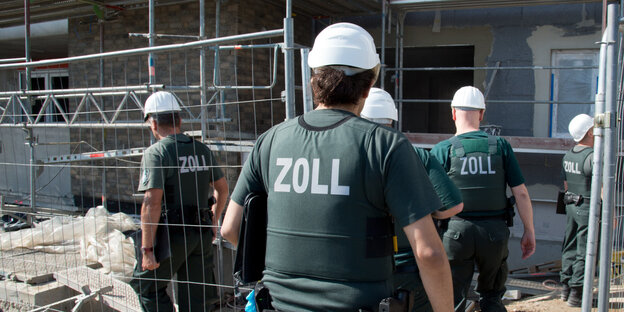Zollbeamte betreten eine Baustelle Zollbeamte betreten eine Baustelle