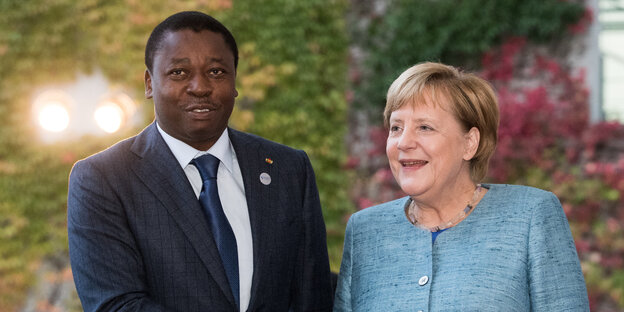 Merkel und Gnassingbe stehen nebeneinander Merkel und Gnassingbe stehen nebeneinander