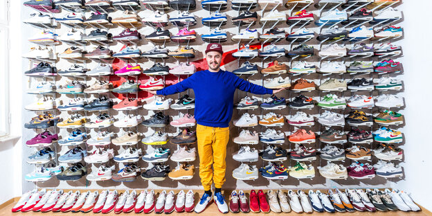 Janiv Koll steht vor seinem Schuhregal und lächelt Janiv Koll steht vor seinem Schuhregal und lächelt