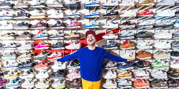 Janiv Koll steht vor seiner Sneakersammlung, aufgestellt über eine ganze Zimmerwand Janiv Koll steht vor seiner Sneakersammlung, aufgestellt über eine ganze Zimmerwand