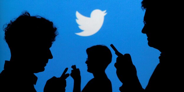 Beschreibung Silhouette von Menschen vor einem Twitterlogo Beschreibung Silhouette von Menschen vor einem Twitterlogo