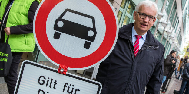 Jürgen Resch, Chef der Deutschen Umwelthilfe, in einem Mantel neben einem Verkehrsschild Jürgen Resch, Chef der Deutschen Umwelthilfe, in einem Mantel neben einem Verkehrsschild