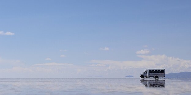 Blauer HImmel mit vereinzelten Wolken, unten sieht es aus, als ob ein Pick-Up auf einem See fahren würde Blauer HImmel mit vereinzelten Wolken, unten sieht es aus, als ob ein Pick-Up auf einem See fahren würde