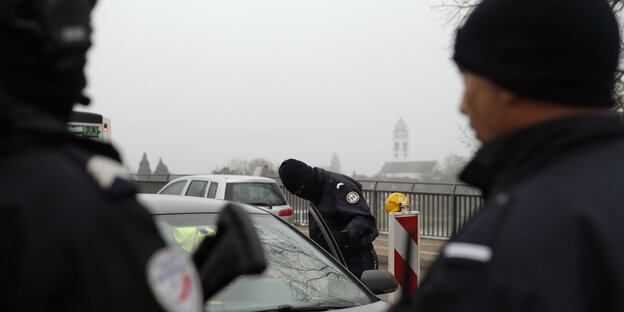 Französische Polizisten kontrollieren ein Auto Französische Polizisten kontrollieren ein Auto