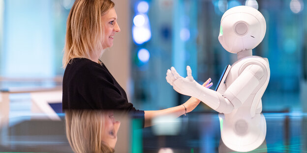 Ein Mensch und ein Roboter unterhalten sich Ein Mensch und ein Roboter unterhalten sich