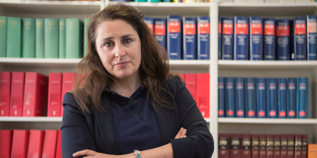 Die Rechtsanwältin Seda Başay-Yıldız steht vor einer Schrankwand mit juristischer Literatur Die Rechtsanwältin Seda Başay-Yıldız steht vor einer Schrankwand mit juristischer Literatur