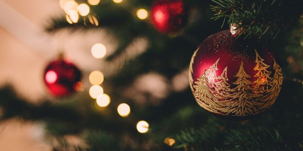 Rote und goldene Kugeln hängen an einem Tannenbaum Rote und goldene Kugeln hängen an einem Tannenbaum