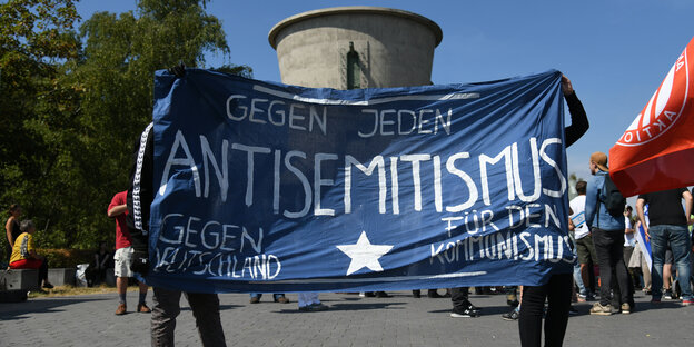 emonstranten protestieren mit einem Transparent mit der Aufschrift «gegen jeden Antisemitismus gegen Deutschland. emonstranten protestieren mit einem Transparent mit der Aufschrift «gegen jeden Antisemitismus gegen Deutschland.
