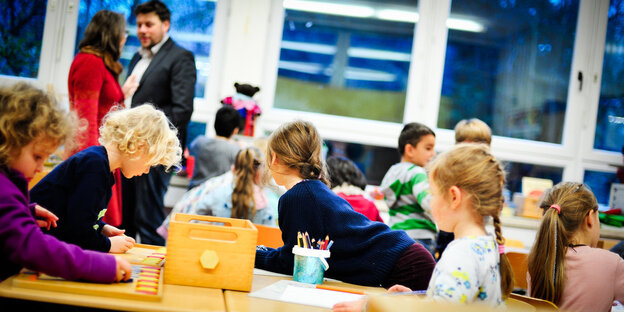 Grundschulkinder sitzen in einem Klassenzimmer.