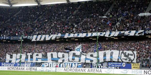 Eine Stadiontribüne voller HSV-Fans, die große Plakate gespannt haben, auf denen steht: Hate Racism Eine Stadiontribüne voller HSV-Fans, die große Plakate gespannt haben, auf denen steht: Hate Racism