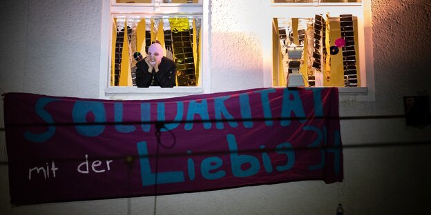 Eine vermummte Person schaut aus einem Fenster in der Liebigstraße 34 Eine vermummte Person schaut aus einem Fenster in der Liebigstraße 34