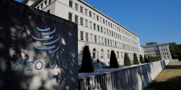 Vor einem großen Gebäude steht ein Schild mit den Buchstaben WTO. Die Abkürzung steht für Welthandelsorganisation Vor einem großen Gebäude steht ein Schild mit den Buchstaben WTO. Die Abkürzung steht für Welthandelsorganisation