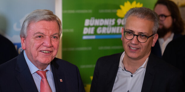 Volker Bouffier und Tarek Al-Wazir, zwei Männer in Anzügen, einer mit Krawatte, der andere mit Brille